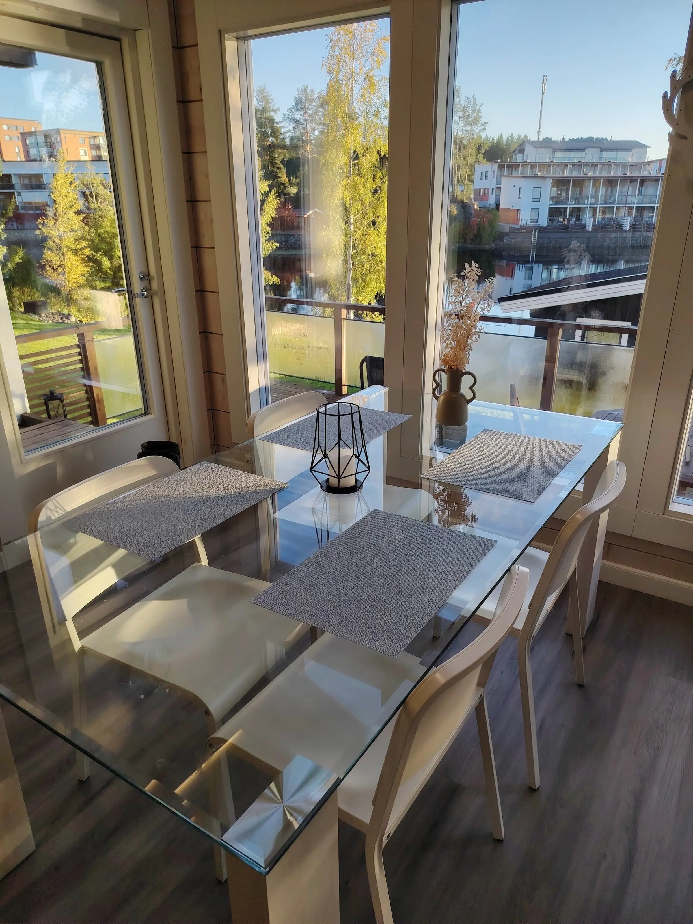 The dining table beside the terrace door, with the lake and buildings on the far shore beyond.
